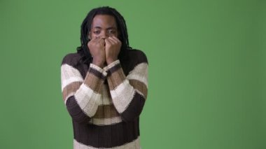 Yeşil bir arka plana dayanır dreadlocks ile genç Afrika yakışıklı