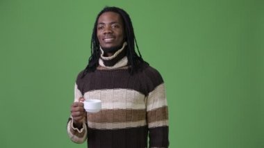 Yeşil bir arka plana dayanır dreadlocks ile genç Afrika yakışıklı