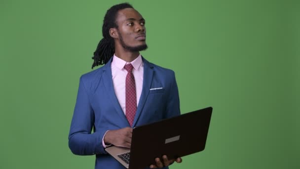 Joven hombre de negocios africano guapo con rastas sobre fondo verde — Vídeos de Stock