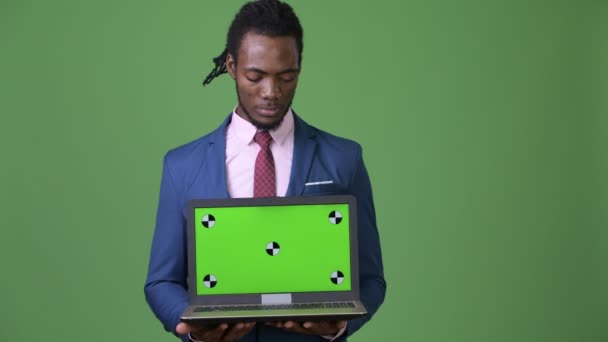 Jovem bonito empresário africano com dreadlocks contra fundo verde — Vídeo de Stock