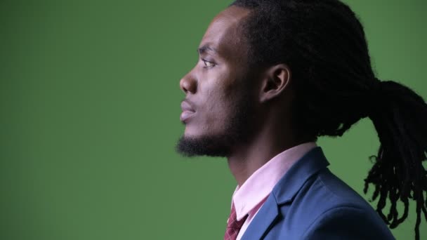 Молодий красивий африканських бізнесмен з дреди на зеленому тлі — стокове відео