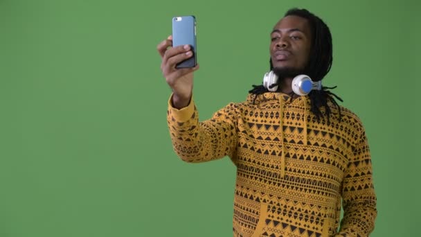 Joven hombre africano guapo con rastas sobre fondo verde — Vídeo de stock