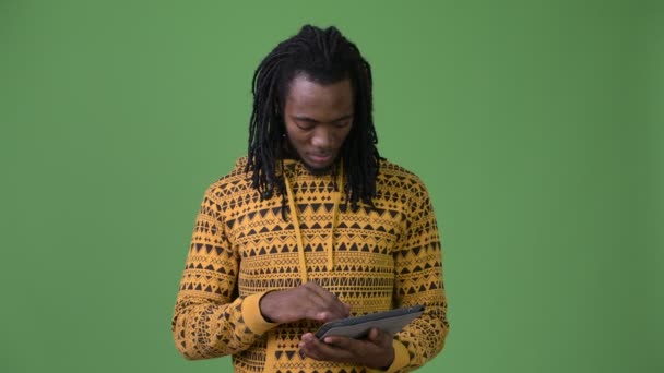 Молодой красивый африканский мужчина с дредами на зеленом фоне — стоковое видео