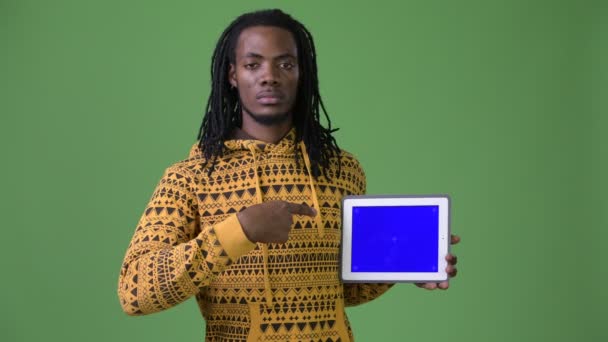 Pěkný africký mladík s dredy před zeleným pozadím — Stock video