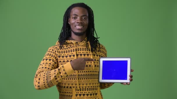 Joven hombre africano guapo con rastas sobre fondo verde — Vídeo de stock