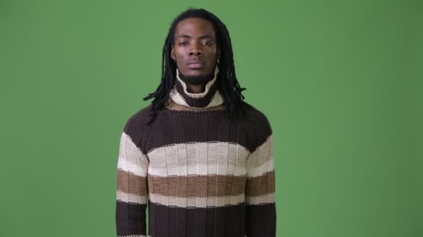 Joven hombre africano guapo con rastas sobre fondo verde — Vídeos de Stock