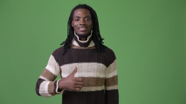 Joven hombre africano guapo con rastas sobre fondo verde — Vídeos de Stock