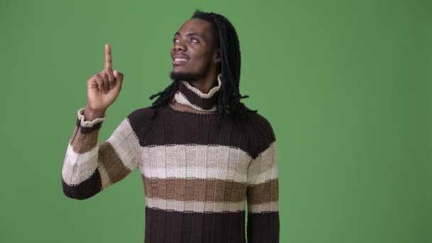 Joven hombre africano guapo con rastas sobre fondo verde — Vídeo de stock