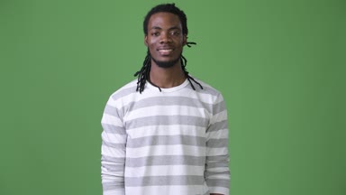 Yeşil bir arka plana dayanır dreadlocks ile genç Afrika yakışıklı