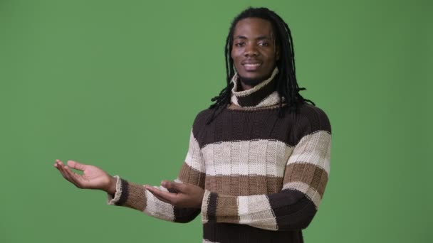 Joven hombre africano guapo con rastas sobre fondo verde — Vídeo de stock