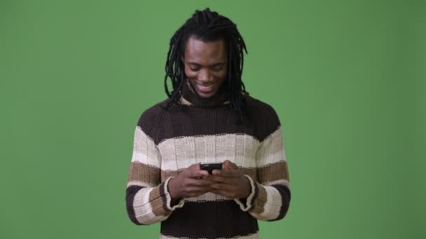 Joven hombre africano guapo con rastas sobre fondo verde — Vídeos de Stock