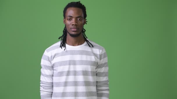 Joven hombre africano guapo con rastas sobre fondo verde — Vídeos de Stock