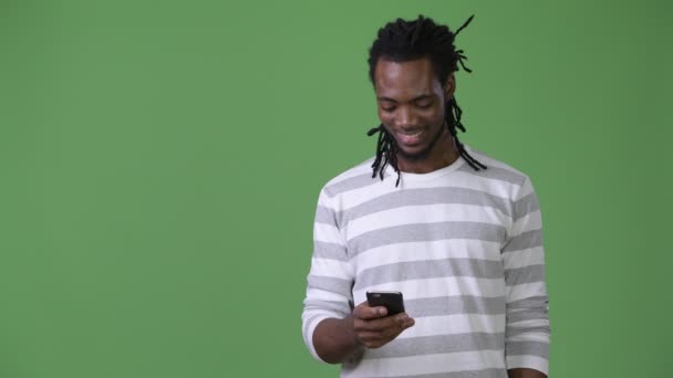 Joven hombre africano guapo con rastas sobre fondo verde — Vídeos de Stock