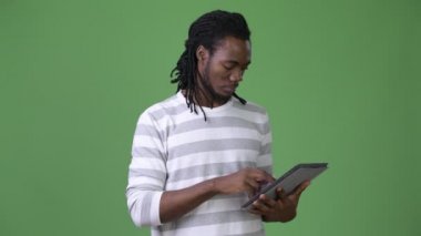 Yeşil bir arka plana dayanır dreadlocks ile genç Afrika yakışıklı