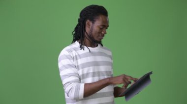 Yeşil bir arka plana dayanır dreadlocks ile genç Afrika yakışıklı