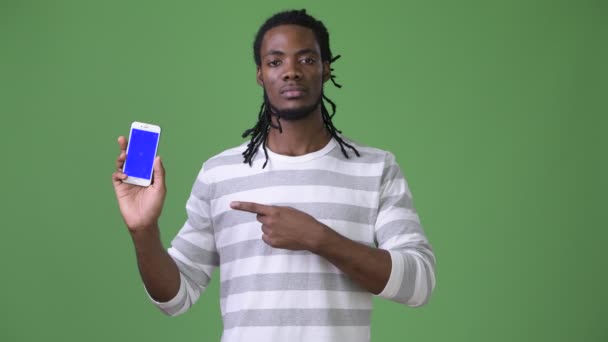 Joven hombre africano guapo con rastas sobre fondo verde — Vídeo de stock