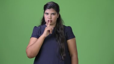 Genç kilolu güzel Hint işkadını yeşil bir arka plana dayanır