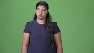 Genç kilolu güzel Hint işkadını yeşil bir arka plana dayanır