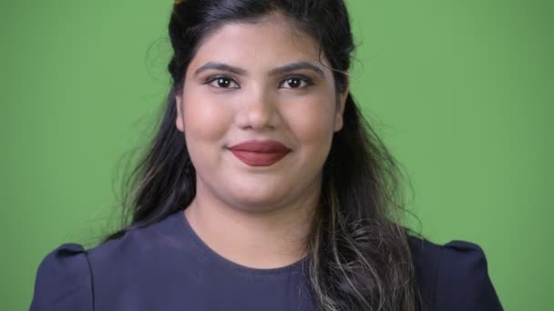 Joven mujer de negocios india hermosa con sobrepeso contra fondo verde — Vídeos de Stock