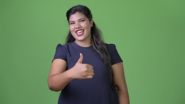 Joven mujer de negocios india hermosa con sobrepeso contra fondo verde — Vídeo de stock