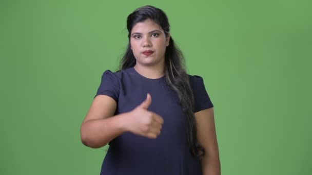 Joven mujer de negocios india hermosa con sobrepeso contra fondo verde — Vídeo de stock