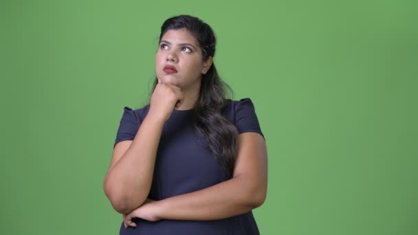 Genç kilolu güzel Hint işkadını yeşil bir arka plana dayanır — Stok video