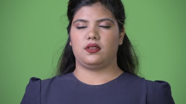 Joven mujer de negocios india hermosa con sobrepeso contra fondo verde — Vídeo de stock