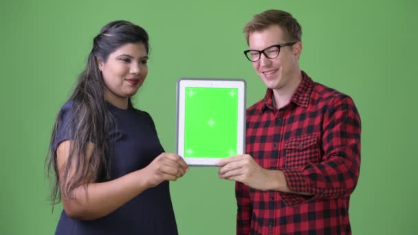 Unga multietniska business par tillsammans mot grön bakgrund — Stockvideo