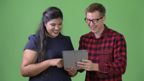 Молода багатоетнічна ділова пара разом на зеленому тлі — стокове відео