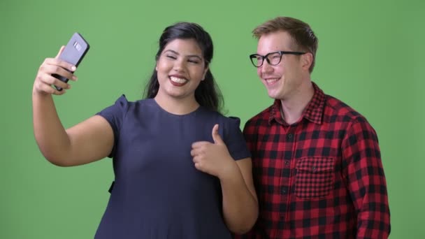 Молодая многонациональная деловая пара вместе на зеленом фоне — стоковое видео