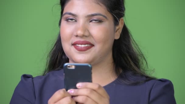 Joven mujer de negocios india hermosa con sobrepeso contra fondo verde — Vídeos de Stock