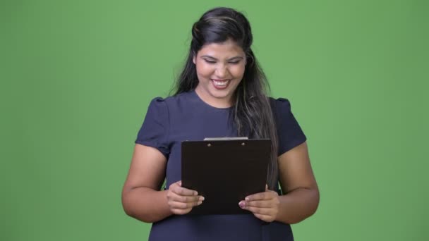 Νέοι υπέρβαροι όμορφη ινδική επιχειρηματίας ενάντια σε πράσινο φόντο — Αρχείο Βίντεο