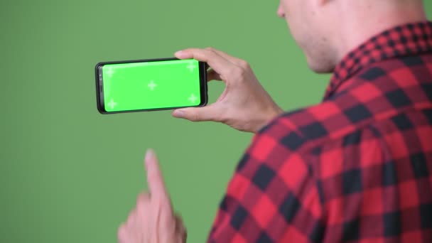 Jovem empresário escandinavo usando telefone celular contra fundo verde — Vídeo de Stock