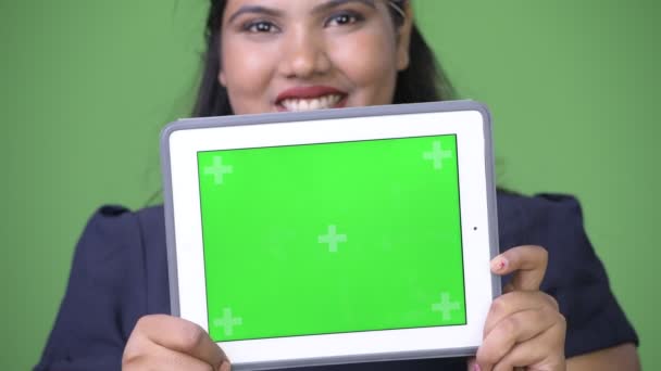 Joven mujer de negocios india hermosa con sobrepeso contra fondo verde — Vídeo de stock