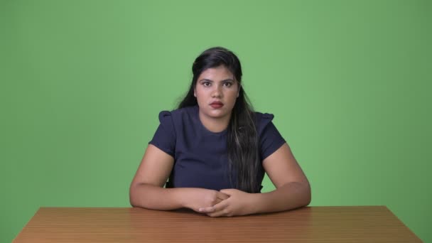 Joven mujer de negocios india hermosa con sobrepeso contra fondo verde — Vídeos de Stock