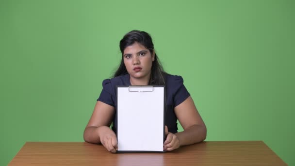 Joven mujer de negocios india hermosa con sobrepeso contra fondo verde — Vídeo de stock