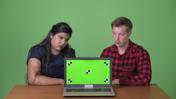 Joven pareja de negocios multiétnicos juntos contra el fondo verde — Vídeos de Stock