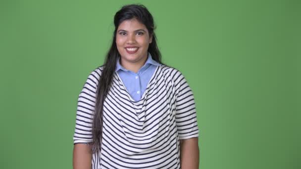 Joven mujer de negocios india hermosa con sobrepeso contra fondo verde — Vídeo de stock