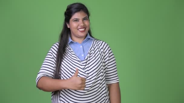 Молодая толстая красивая индийская предпринимательница на зеленом фоне — стоковое видео