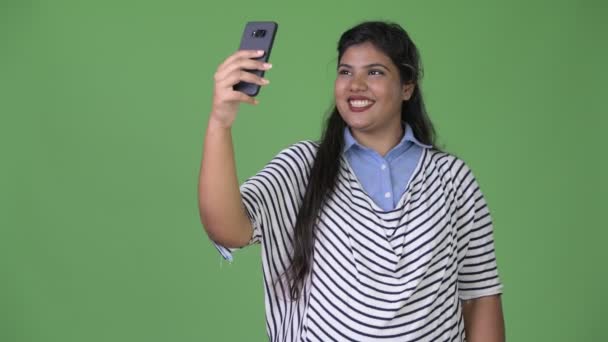 Молодая толстая красивая индийская предпринимательница на зеленом фоне — стоковое видео