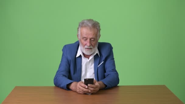 Stilig seniorskäggig affärsman mot grön bakgrund — Stockvideo
