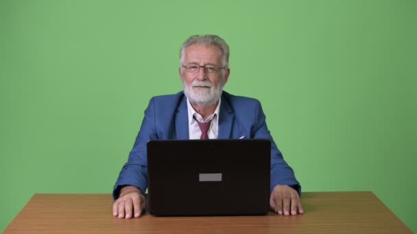 Jóképű idősebb szakállas üzletember zöld háttérrel — Stock videók