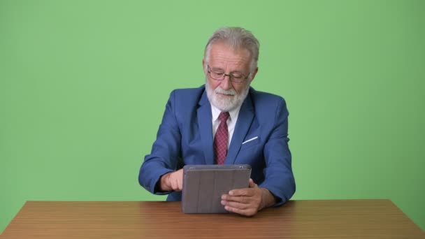 Yeşil geçmişi olan yakışıklı, yaşlı, sakallı bir iş adamı. — Stok video