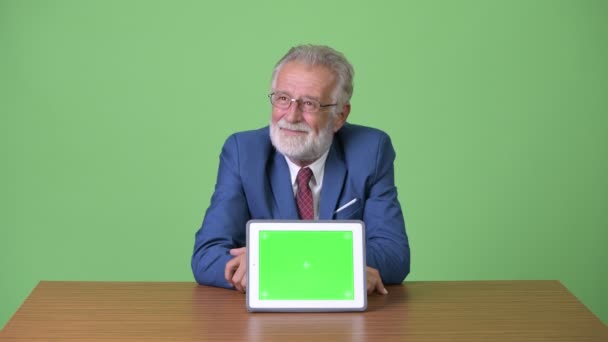 Pohledný starší vousatý podnikatel proti zelenému pozadí — Stock video