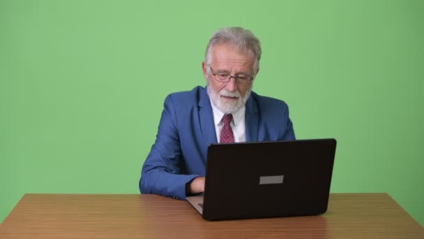 Красивий старший бородатий бізнесмен на зеленому тлі — стокове відео