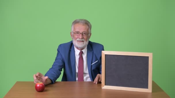 Guapo hombre de negocios barbudo senior contra fondo verde — Vídeos de Stock