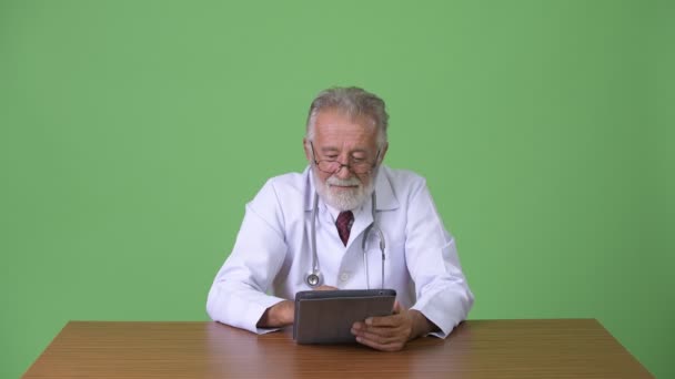 สวยงามอาวุโสหนวดชายแพทย์กับพื้นหลังสีเขียว — วีดีโอสต็อก