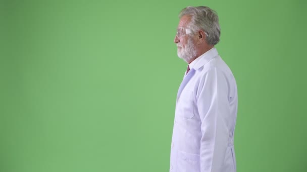 Красавчик старший бородатый врач на зеленом фоне — стоковое видео