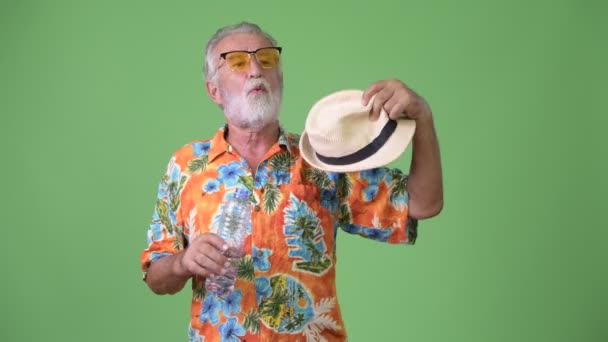 Красивый старший бородатый турист готов к отпуску на зеленом фоне — стоковое видео