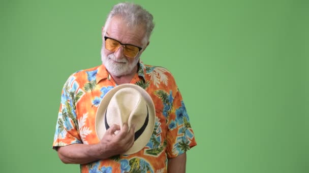 Przystojny senior Brodaty mężczyzna turystycznych gotowy na wakacje na zielonym tle — Wideo stockowe